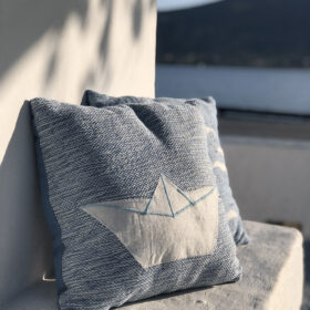 Handwoven cushion with white boat